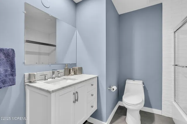 a bathroom with a granite countertop sink toilet and mirror