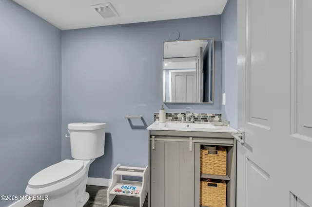 a bathroom with a toilet sink and mirror