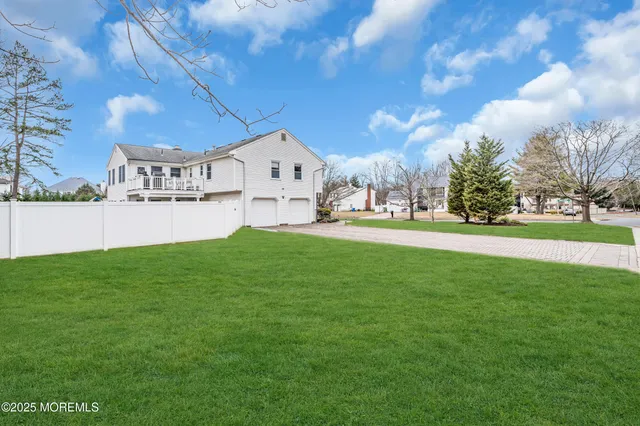a view of a house with a big yard and large trees