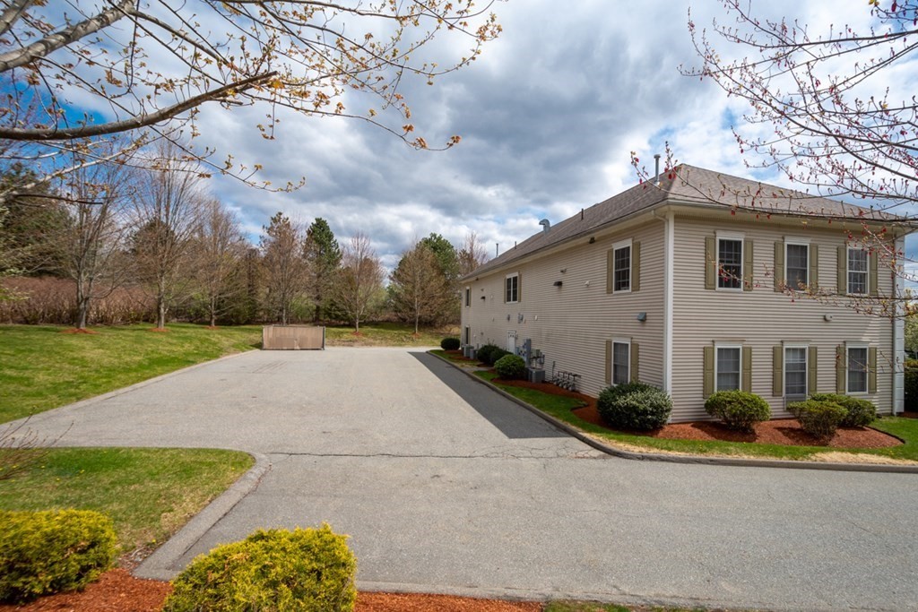 36 Webb Brook Road, Unit 4 Billerica, MA 01821 - Photo 20 of 21 a front view of a house with a yard and garage