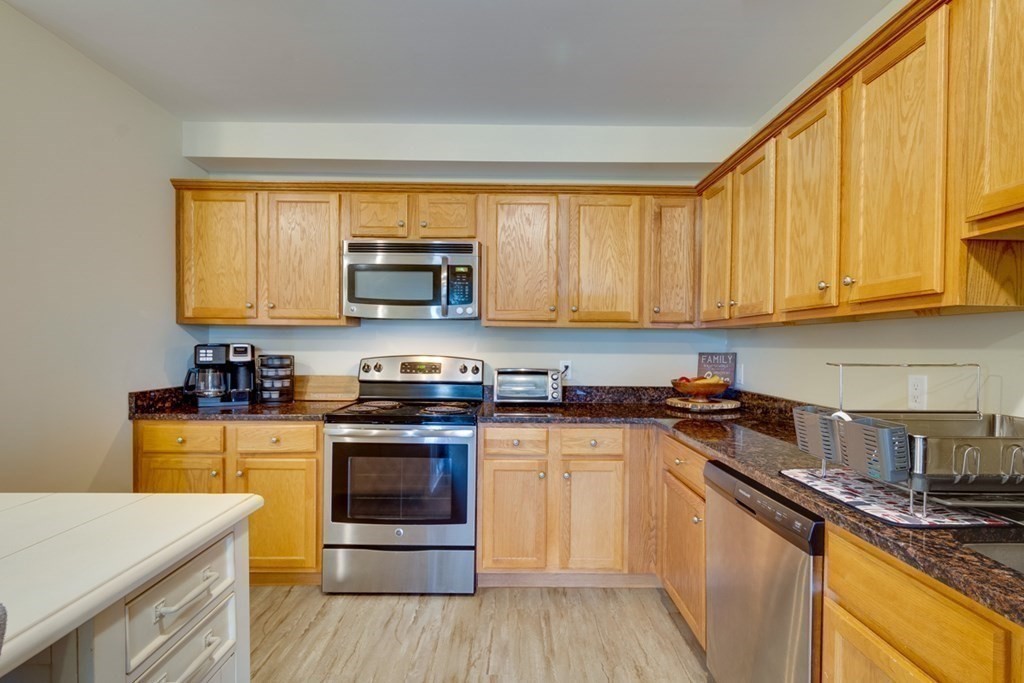 36 Webb Brook Road, Unit 4 Billerica, MA 01821 - Photo 8 of 21 a kitchen with stainless steel appliances granite countertop a stove a sink and a microwave
