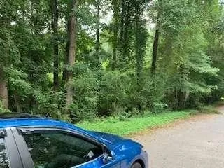 an aerial view of residential house with outdoor space and trees all around