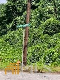 an aerial view of residential house with outdoor space and trees all around