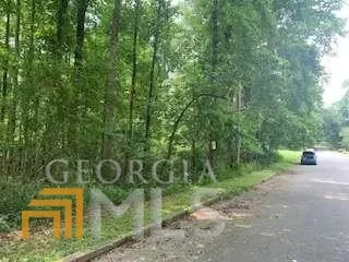 an aerial view of residential house with outdoor space and trees all around