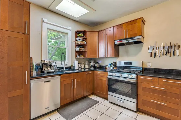 a kitchen with stainless steel appliances granite countertop a stove a sink and a microwave