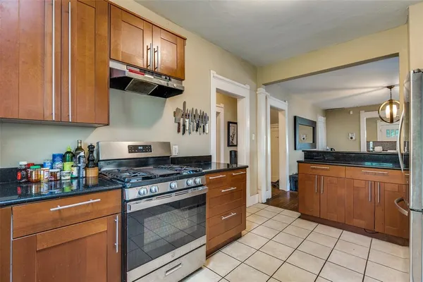a kitchen with stainless steel appliances granite countertop a stove a sink and a refrigerator