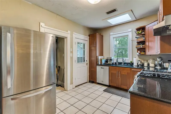 a kitchen with stainless steel appliances granite countertop a refrigerator and a sink