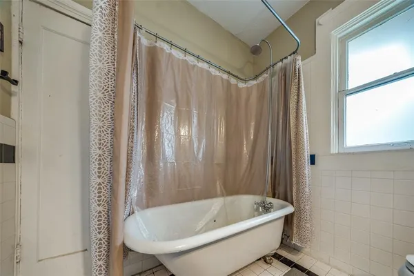 a bathroom with a tub and shower curtain