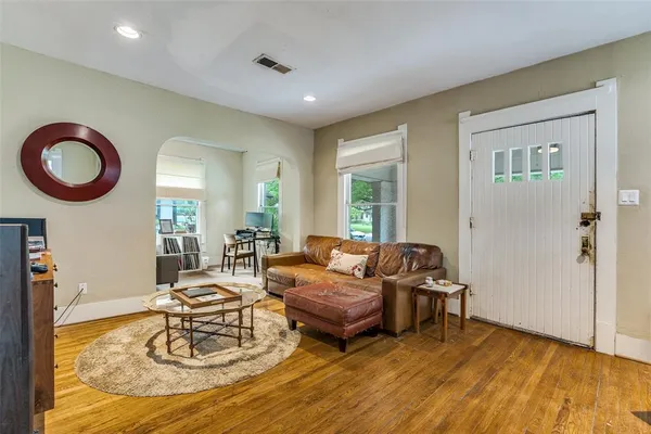 a living room with furniture and a wooden floor