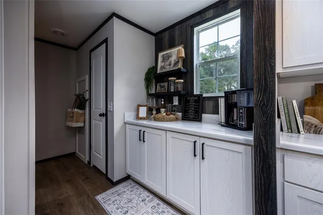 a kitchen with white cabinets and a window