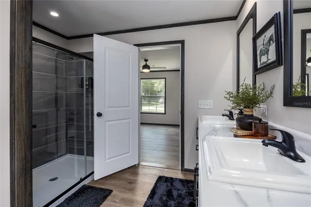 a bathroom with a sink a glass door shower and mirror