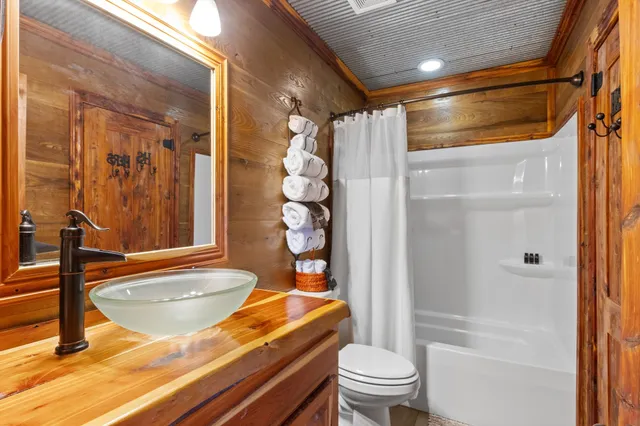 a bathroom with a granite countertop bathtub shower sink vanity and toilet