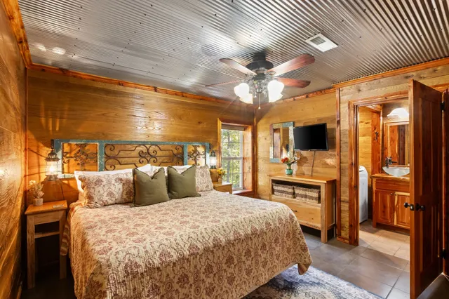 a bedroom with a large bed and a flat tv screen