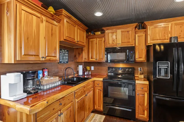 a kitchen with stainless steel appliances granite countertop a refrigerator and a stove top oven