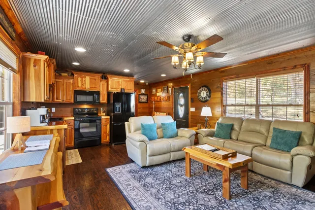 a living room with furniture kitchen view and a large window
