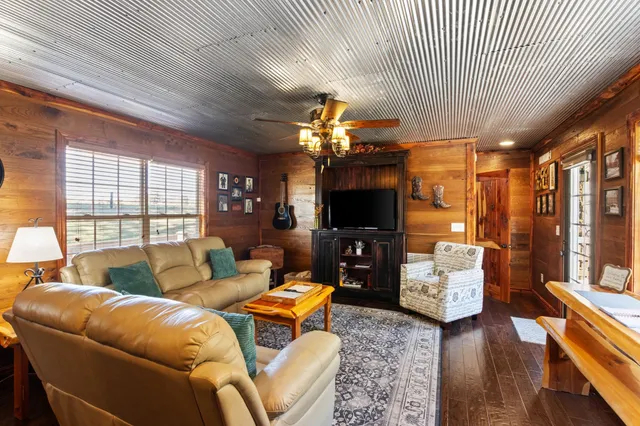 a living room with furniture a flat screen tv and a fireplace