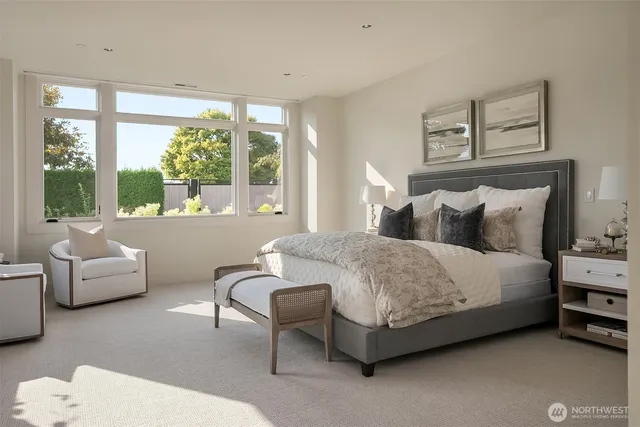 a bedroom with a bed and a couch with large window