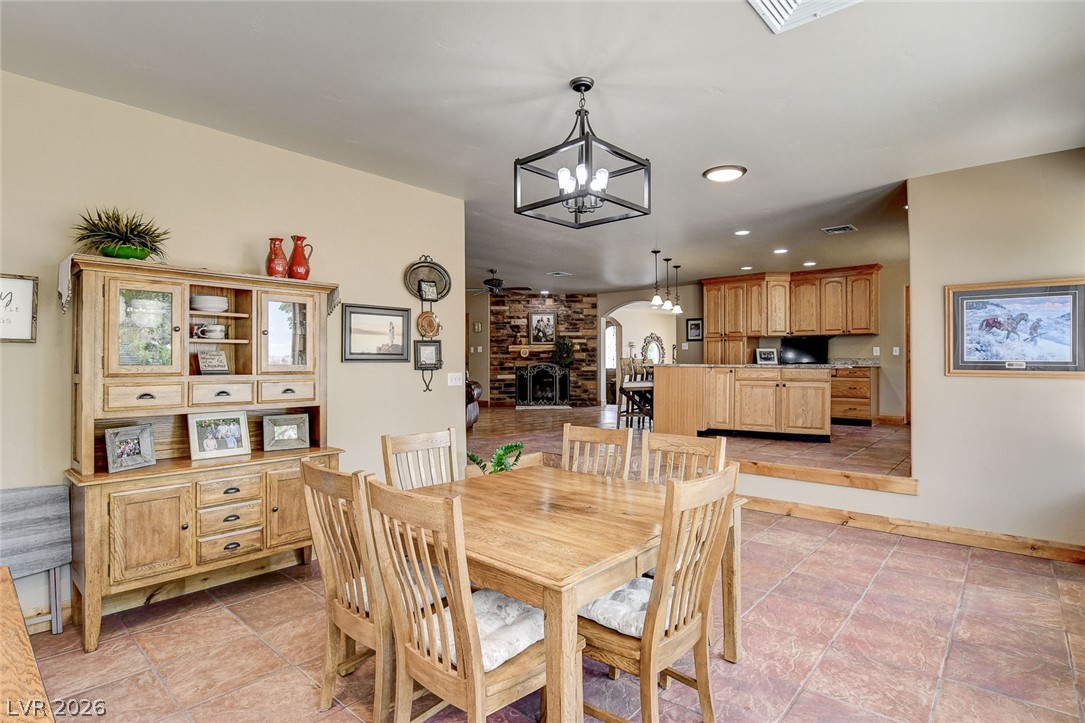 1950 Bowman Road Logandale, NV 89021 - Photo 19 of 81 A rustic dining area transitions into a cozy living space with a wood burning fireplace.