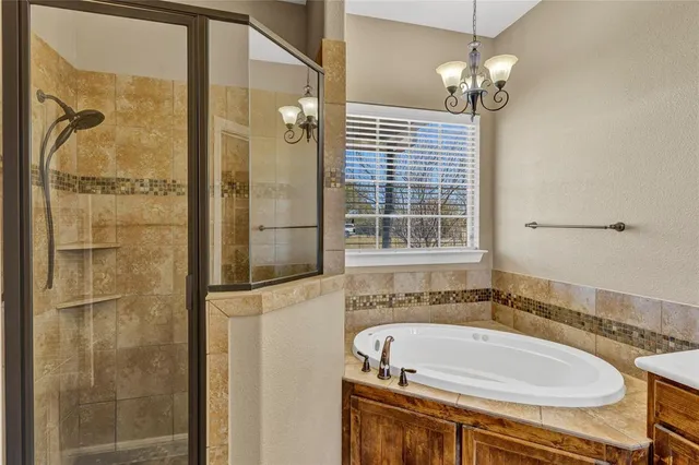a bathroom with a tub a sink and mirror