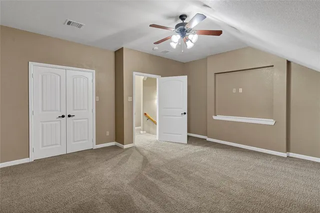 a view of an empty room with a chandelier fan