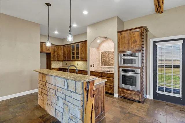a kitchen with a stove a refrigerator and a oven