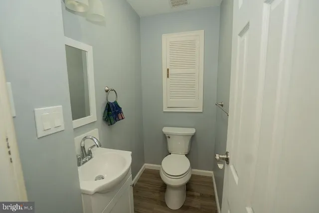 a bathroom with a toilet a sink and mirror