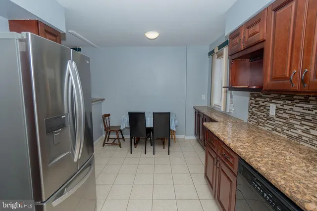 a kitchen with granite countertop a refrigerator and a stove top oven