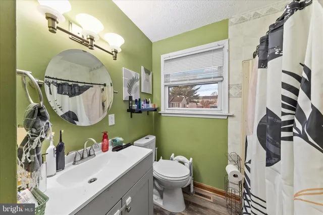 a bathroom with a sink mirror vanity and toilet