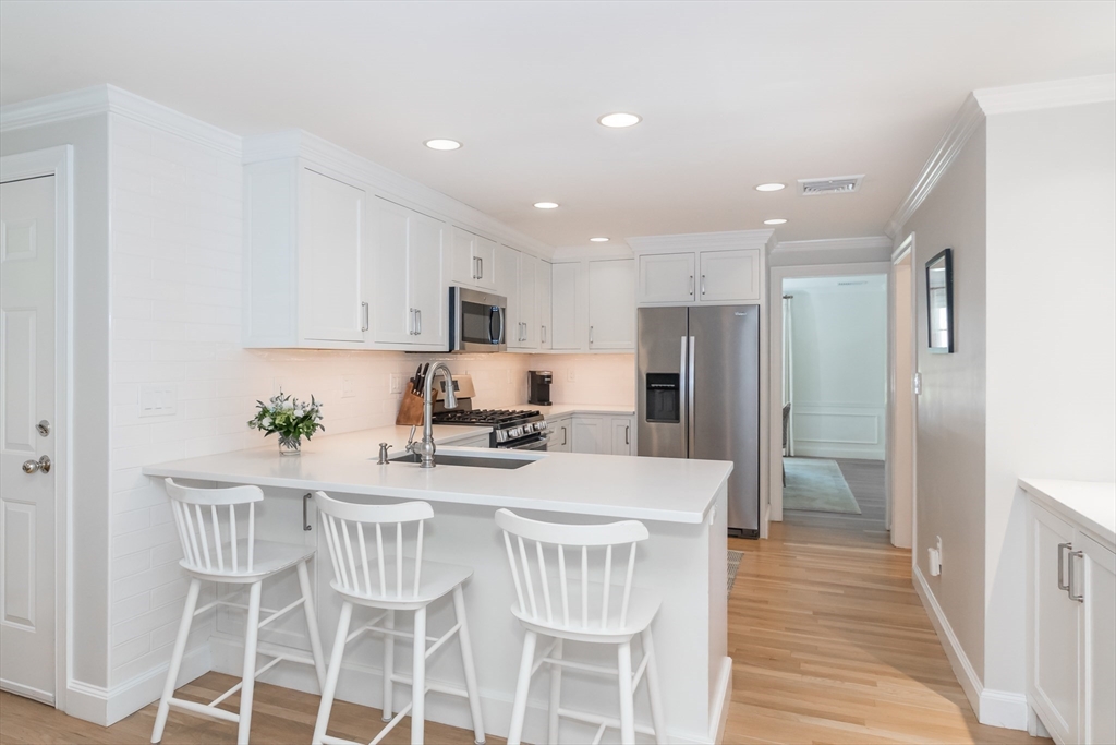 31 Martin Road Wellesley, MA 02481 - Photo 9 of 28 a kitchen with stainless steel appliances kitchen island granite countertop a refrigerator and a stove top oven
