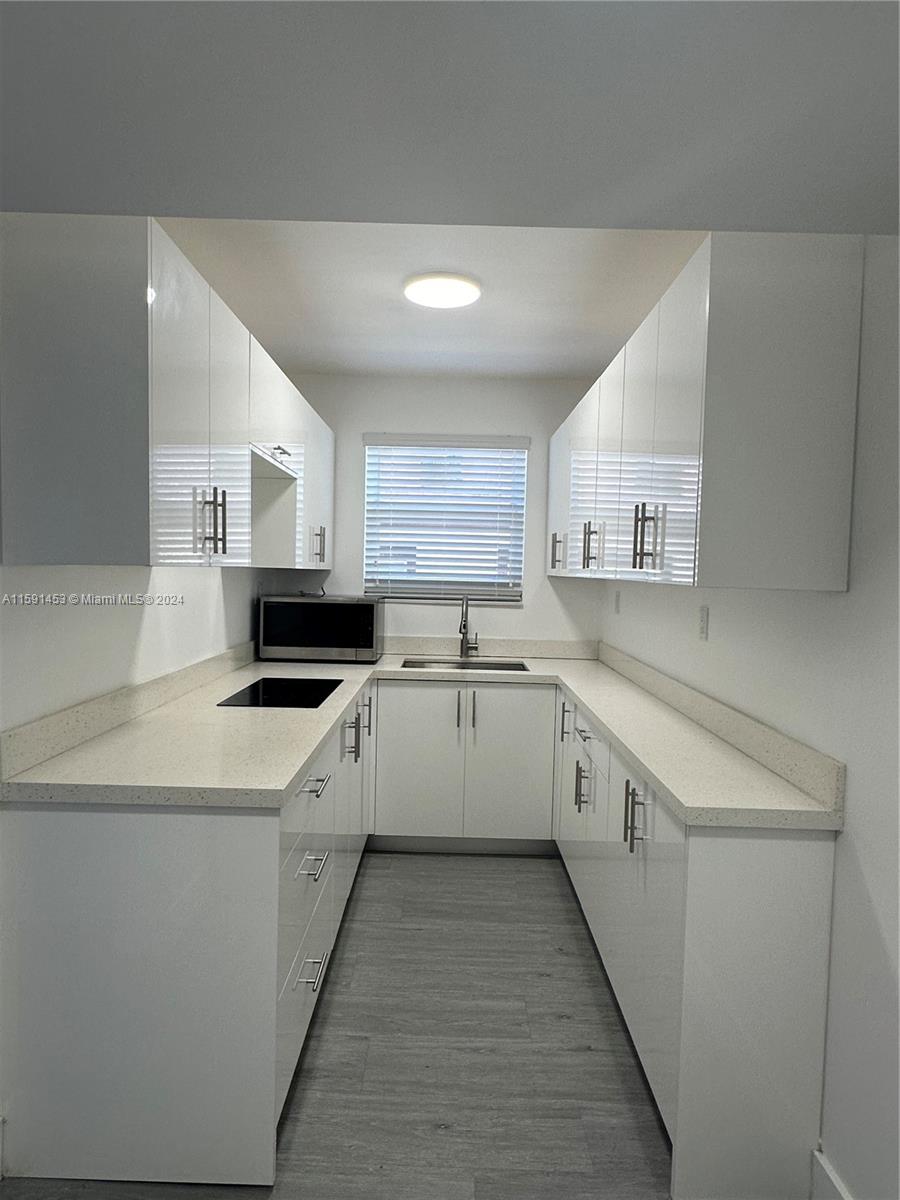 502 Southwest 27th Avenue, Unit 4 Miami, FL 33135 - Photo 4 of 11 a large white kitchen with cabinets a sink and white appliances