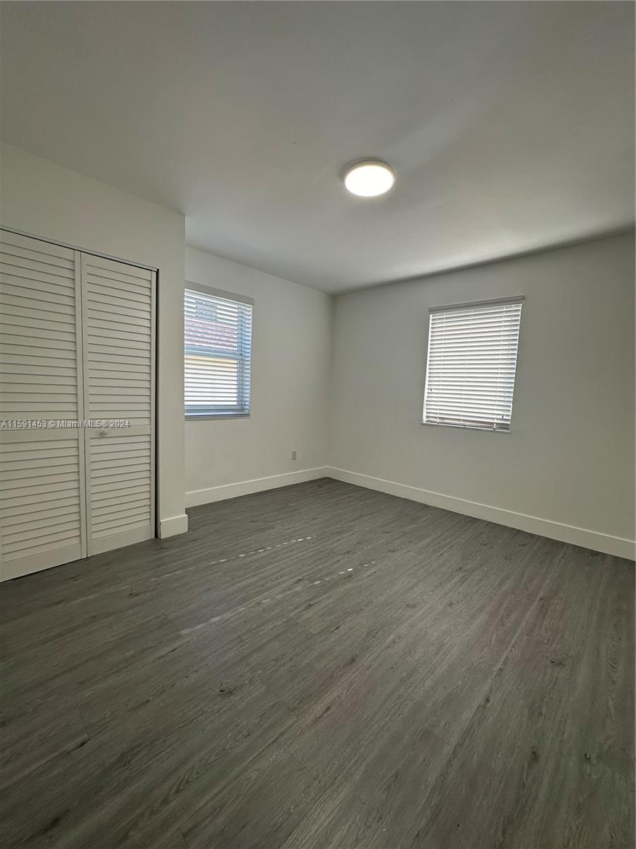 502 Southwest 27th Avenue, Unit 4 Miami, FL 33135 - Photo 6 of 11 an empty room with wooden floor and windows
