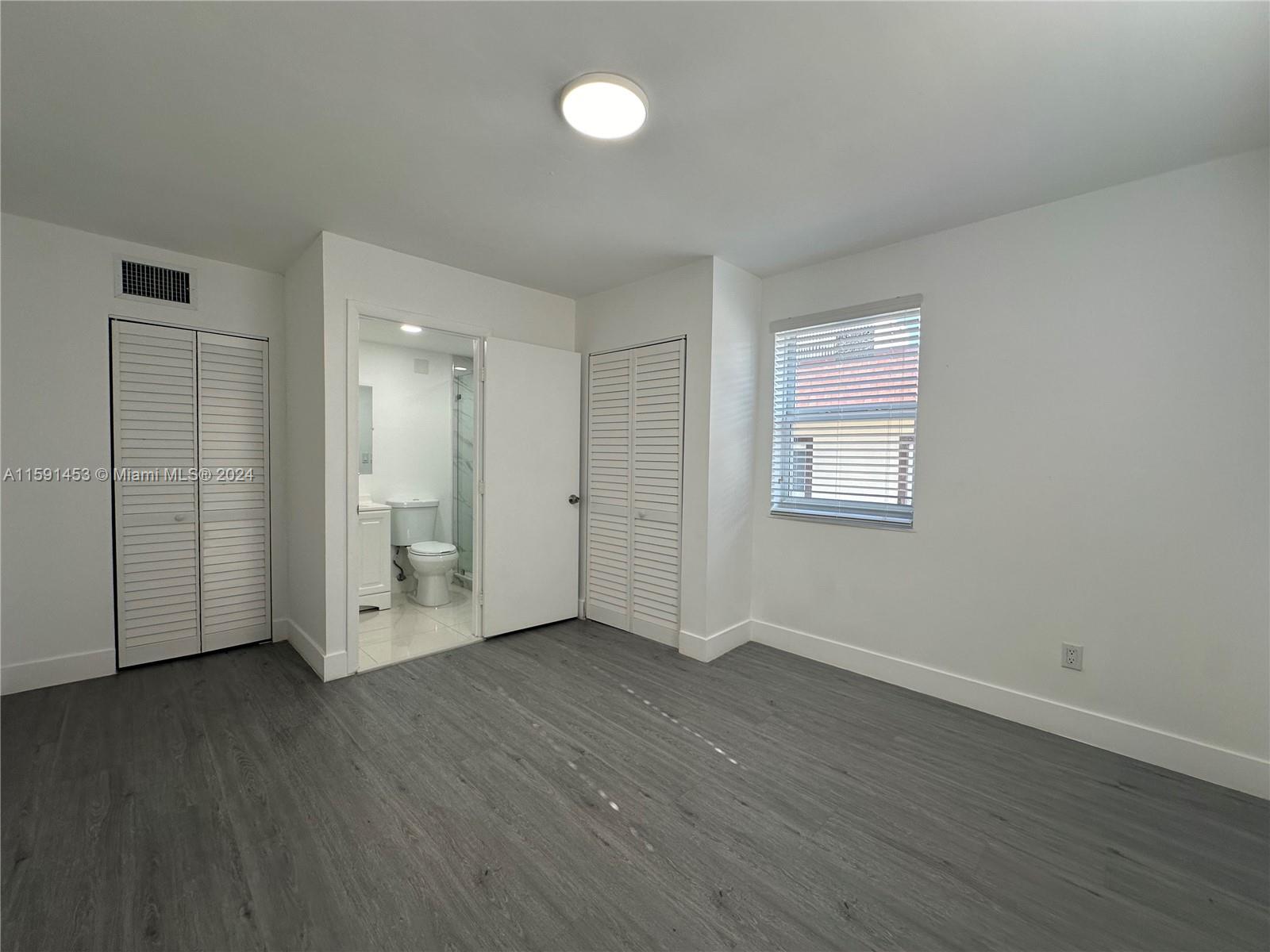 502 Southwest 27th Avenue, Unit 4 Miami, FL 33135 - Photo 7 of 11 a view of an empty room with wooden floor and a window