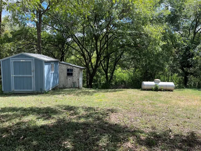a view of backyard with deck and a garden