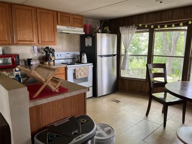 a kitchen with a refrigerator a stove a sink and a cabinets