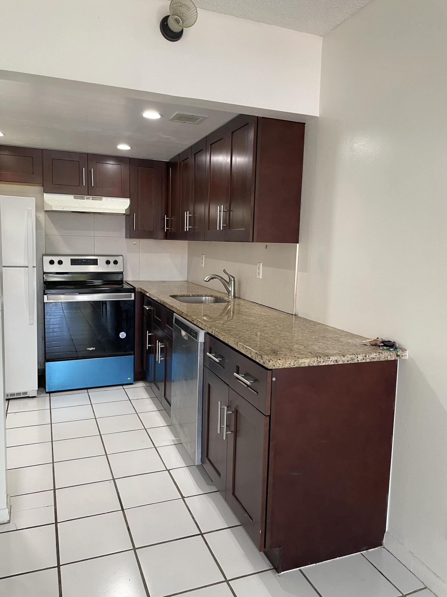 636 Northwest 13th Street, Unit 380 Boca Raton, FL 33486 - Photo 1 of 14 a kitchen with stainless steel appliances granite countertop a sink counter space and cabinets