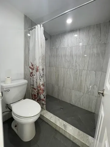 a bathroom with a toilet and shower