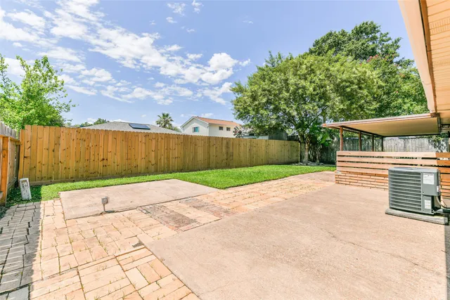 a view of backyard with table and chairs with wooden fence
