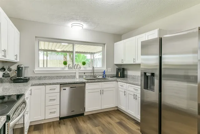 a kitchen with white cabinets and white appliances