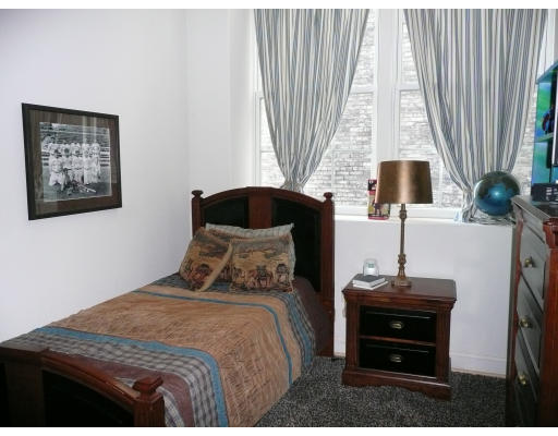 200 Market Street, Unit 3305 Lowell, MA 01852 - Photo 5 of 7 a bedroom with a bed and a flat tv screen
