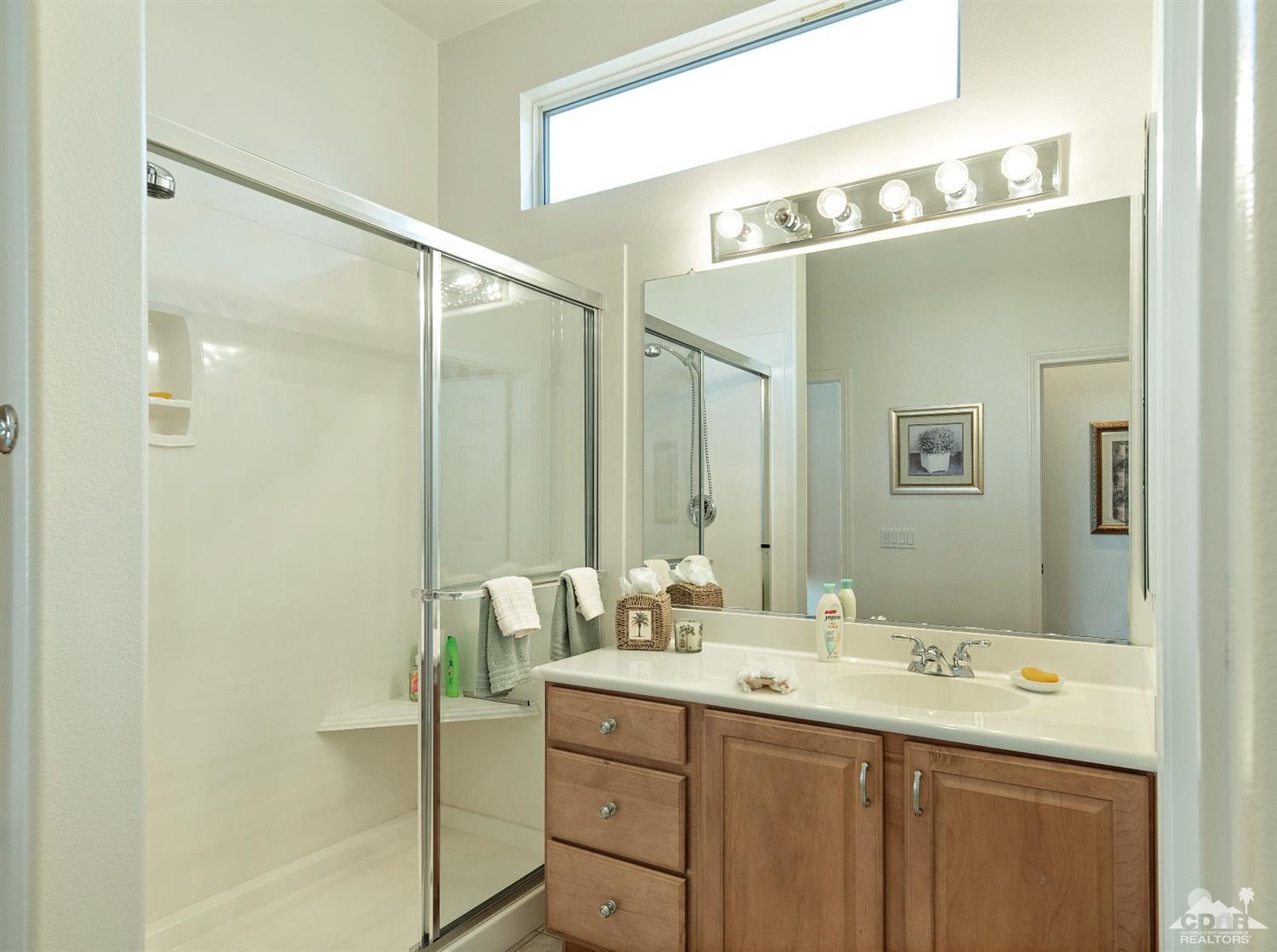 80561 Knightswood Road Indio, CA 92201 - Photo 13 of 25 a bathroom with a double vanity sink and mirror