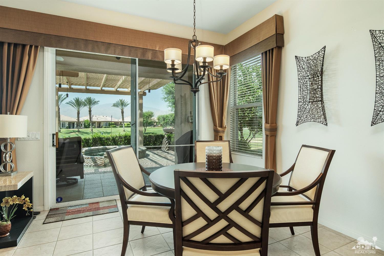 80561 Knightswood Road Indio, CA 92201 - Photo 5 of 25 a view of a dining room with furniture large windows and wooden floor