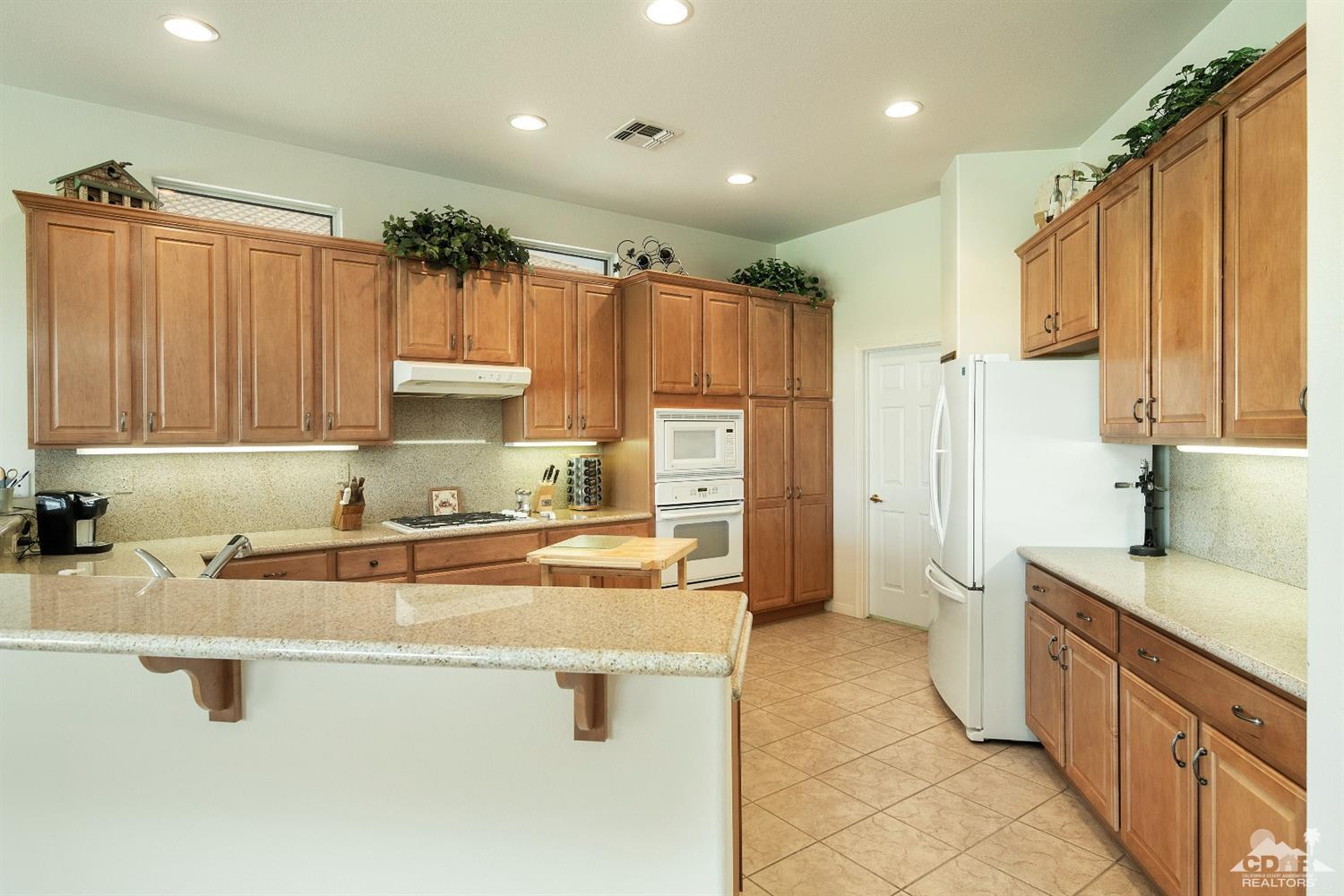 80561 Knightswood Road Indio, CA 92201 - Photo 6 of 25 a kitchen with stainless steel appliances a sink stove and refrigerator