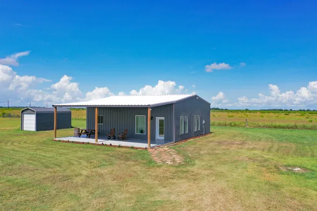 a backyard of a house with outdoor seating and yard
