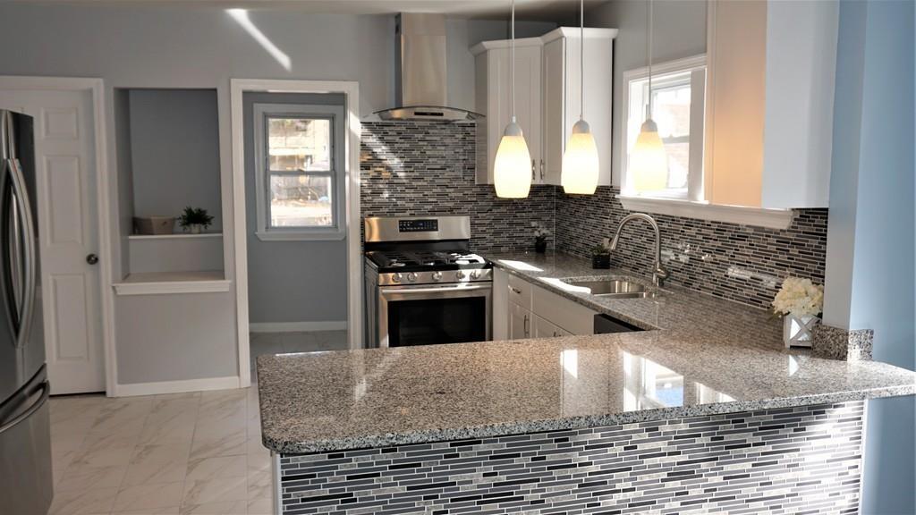 49 Ranney Street Springfield, MA 01108 - Photo 11 of 29 a kitchen with stainless steel appliances granite countertop a stove and a refrigerator