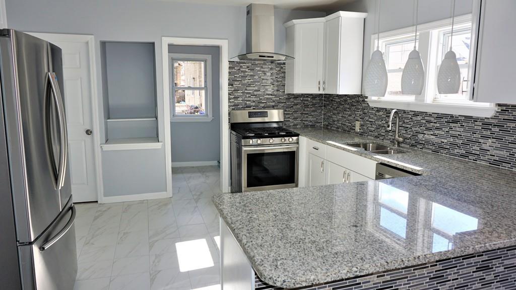 49 Ranney Street Springfield, MA 01108 - Photo 8 of 29 a kitchen with stainless steel appliances granite countertop a stove a refrigerator and a sink