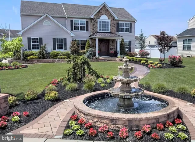a view of a house with a garden in front and porch