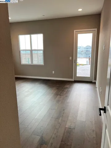 a view of hallway with wooden floor and fence