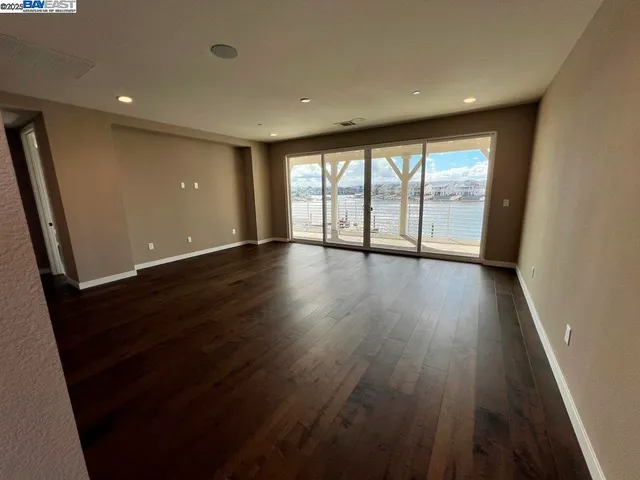 an empty room with wooden floor and sliding door