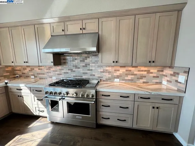 a kitchen with granite countertop a stove a sink and dishwasher