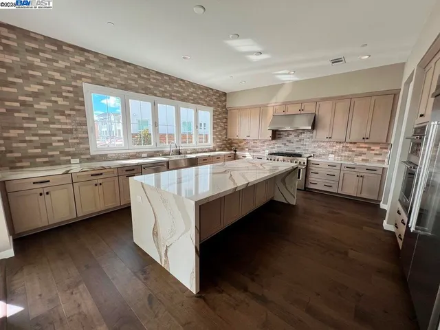 a open kitchen with stainless steel appliances granite countertop a stove refrigerator and a sink